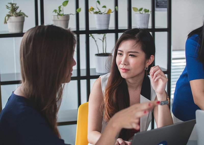 Two women in HR talking about how to enhance HR Efficiencies